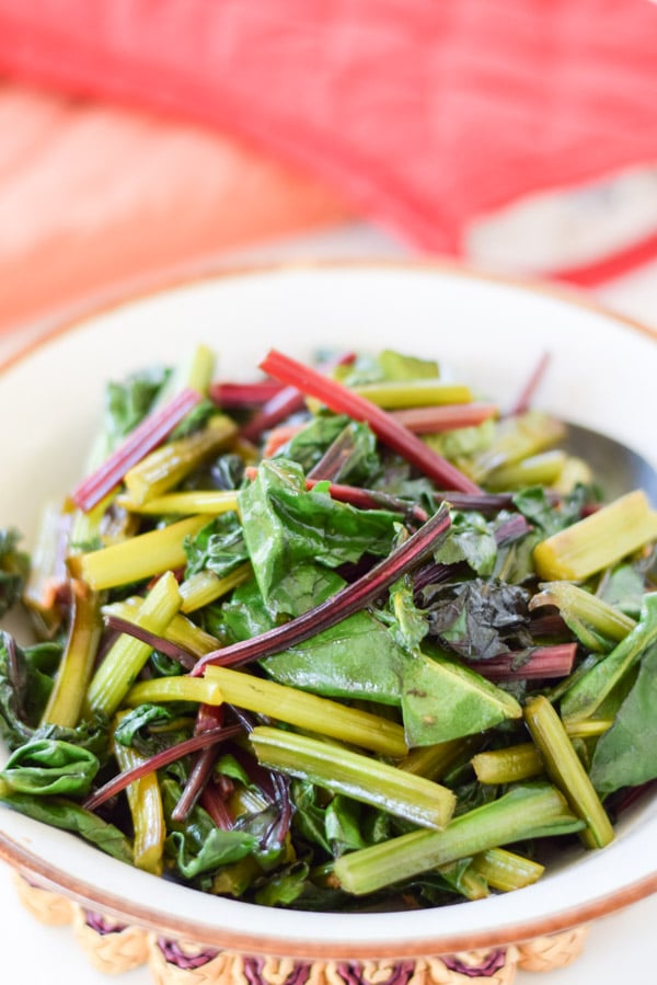 A brown and white bowl filled with the greens