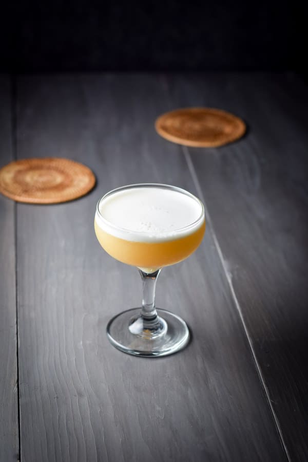 The pretty foamy amber cocktail in a coupe glass