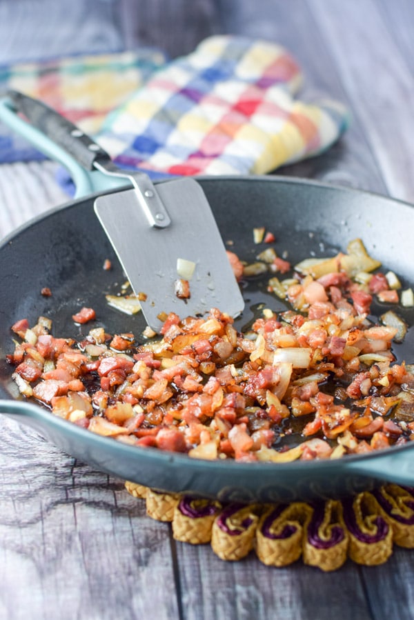 Onion, garlic and pancetta sautéed in a green cast iron pan