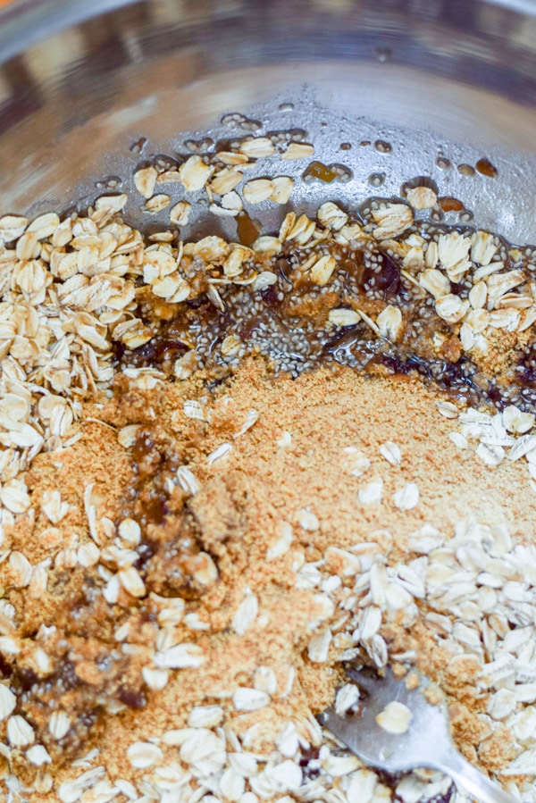 All the ingredients, including oats, chia seeds and flax meal in a metal bowl ready to be mixed