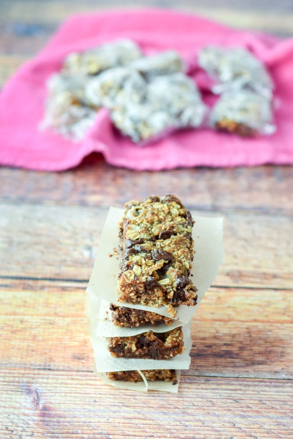 Granola bars with chocolate chips in a stack of four n front of wrapped bars