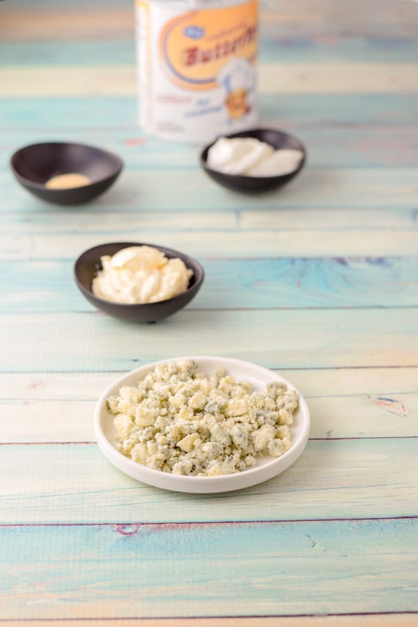 Blue cheese, sour cream, mayonnaise, spices and buttermilk on a green background