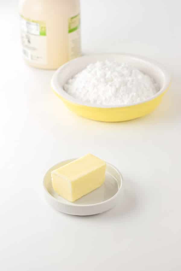 Butter, confectioner's sugar and maple syrup for the glaze on a white background