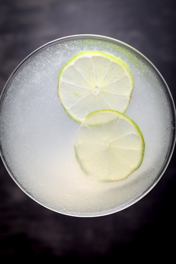 Overhead view of the gimlet with two thin lime wheels floating in it