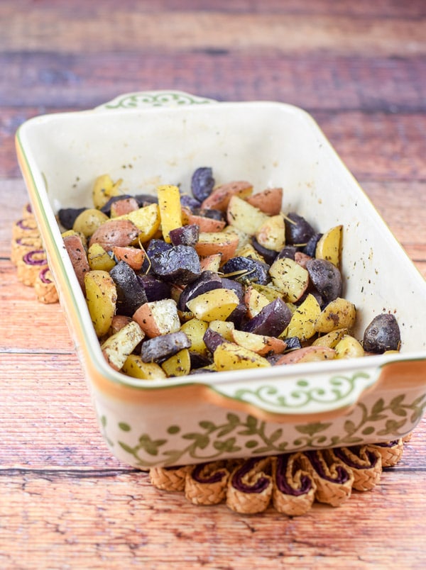 A baking dish with the potatoes roasted in it fresh out of the oven