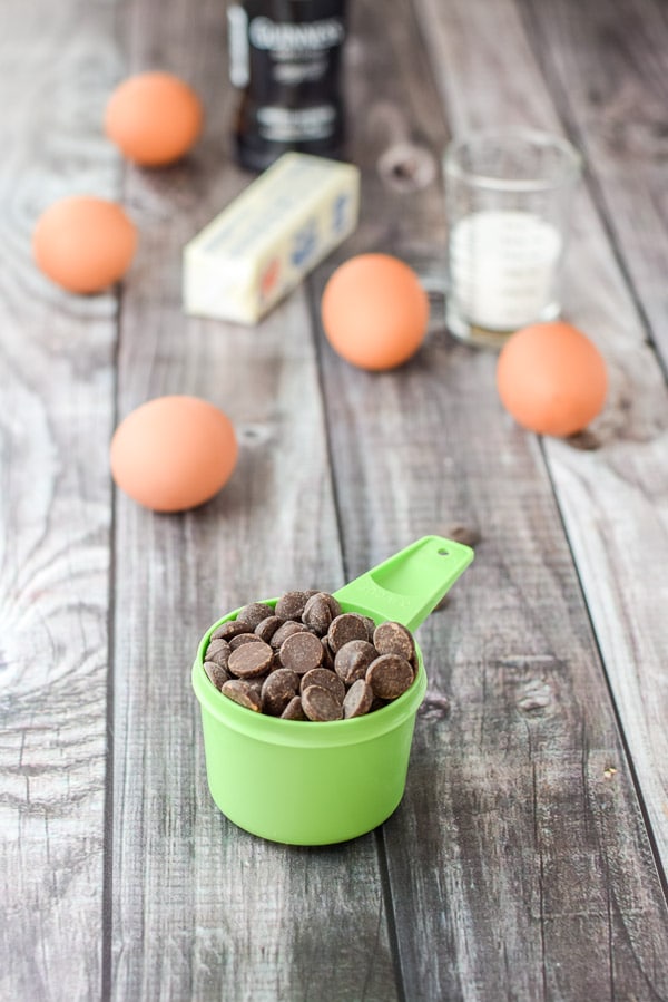 Chocolate chips, eggs, butter, cream and guinness on a grey table