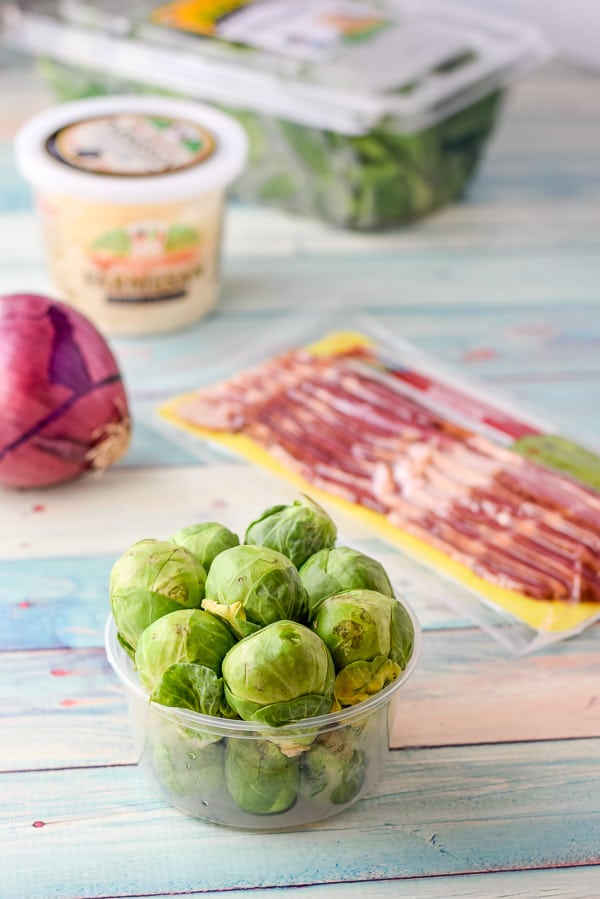 Brussel sprout, bacon, red onion, cheese and spinach on a table