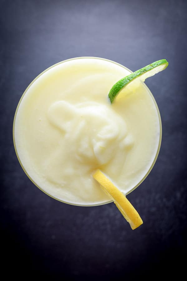 Aerial view of the lemon margarita with lemon and lime wheel garnish