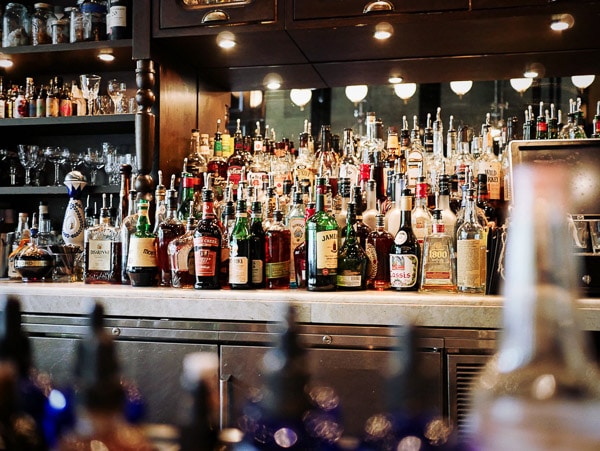 Restaurant bar with lots of bottles, some of the bottles are out of focus in front