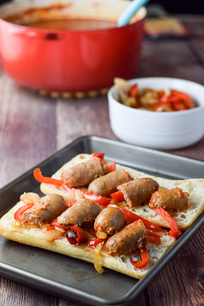 Sausage cut up and placed on the vegetables on the bread