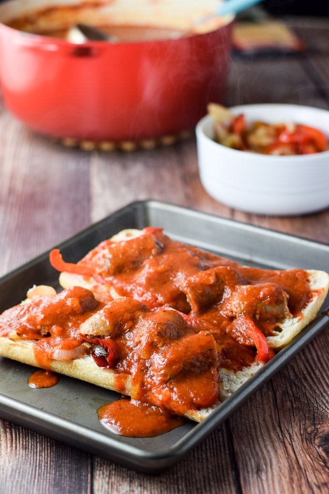 Gravy ladled on the sausage on the bread