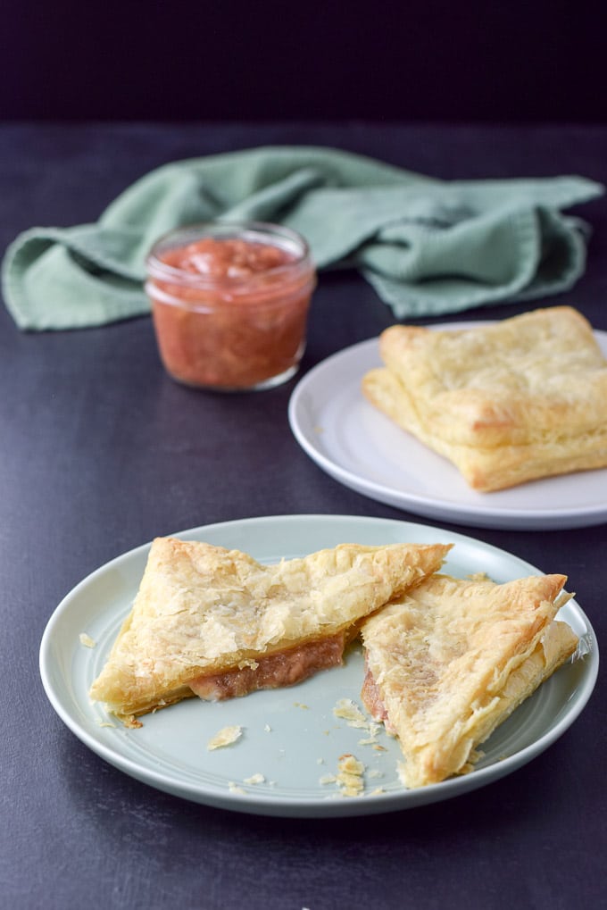 A green plate with a cut piece of baked pastry square with rhubarb in it