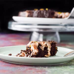 Vertical view of the chocolate cake with marshmallow dripping. There is also the cake in the background - square