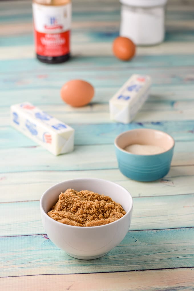 The ingredients - brown sugar, sugar, butter, eggs, baking soda and vanilla on a green table
