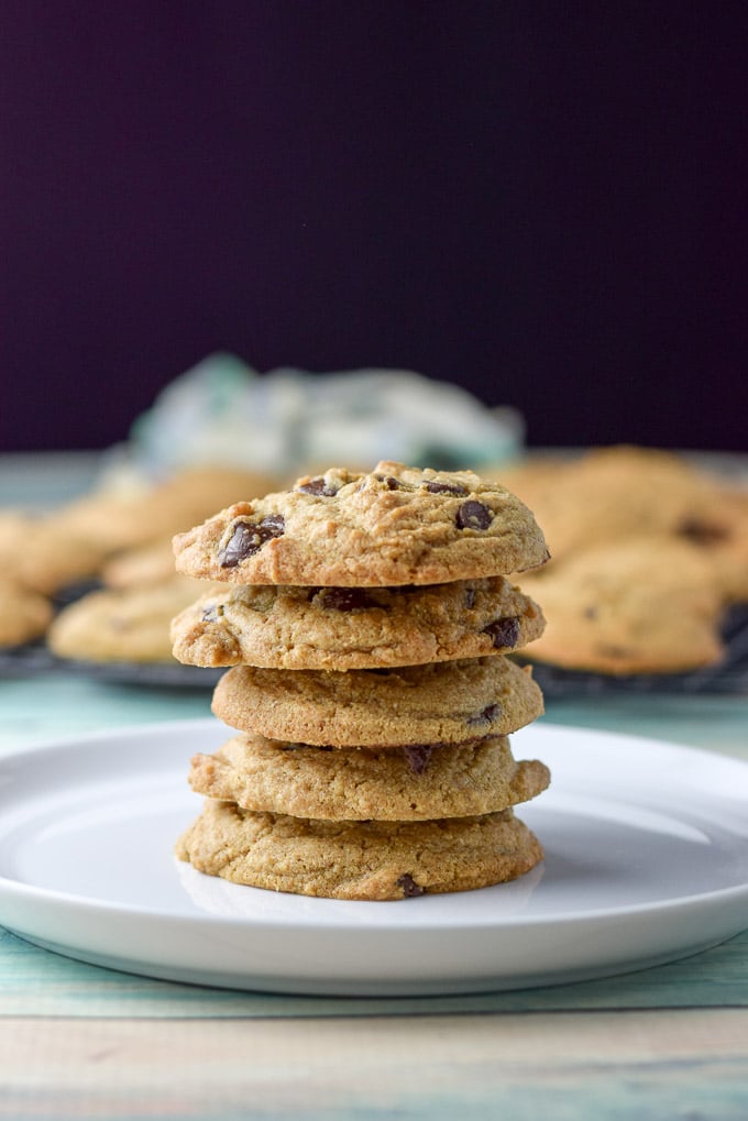 Vertical shot of five of the cookies on top of each other. There is a rack of cookies in the background