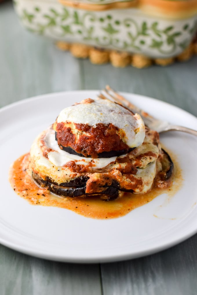 Close up of the white plate with the eggplant rounds, gravy and cheese