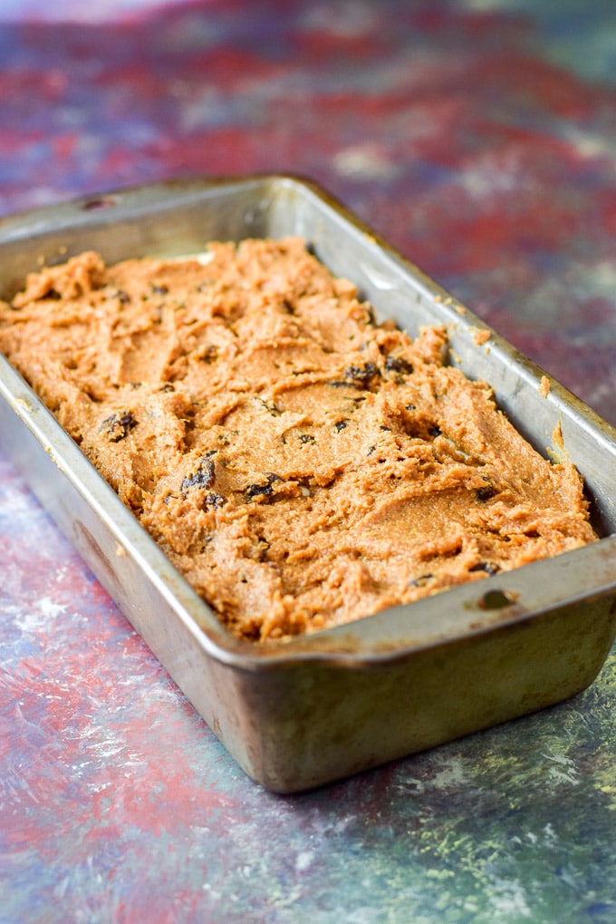 Last of the pumpkin batter spread on the cheesecake layer in the bread pan