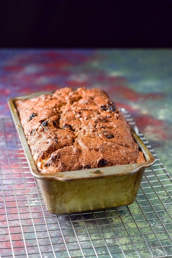 A pan of baked pumpkin bread on a metal rack