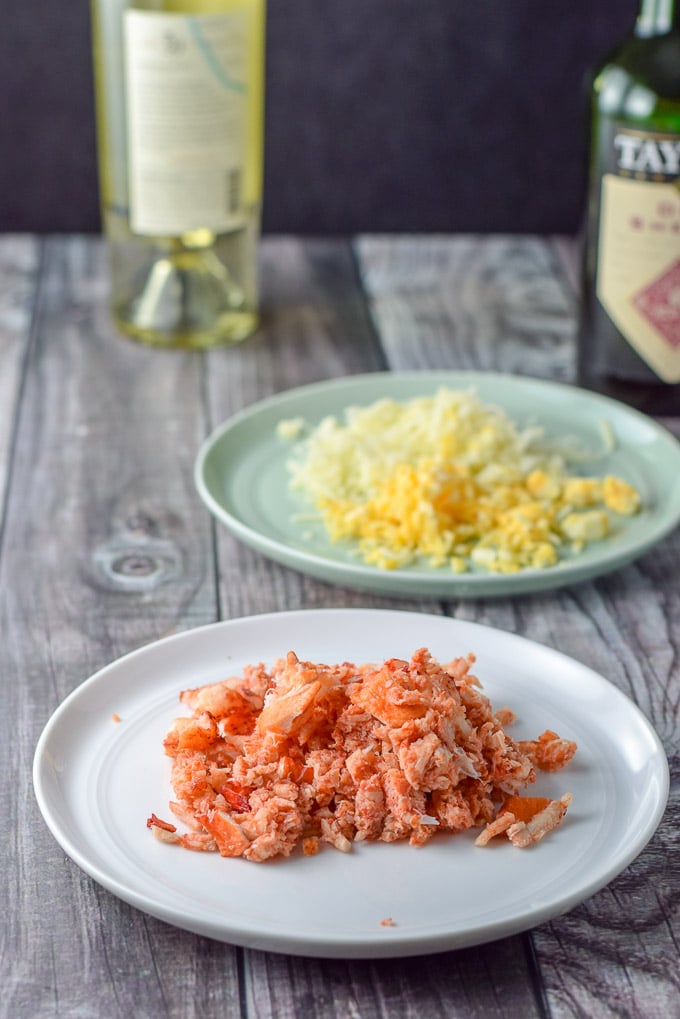 Lobster meat cut up, shredded cheese, sherry and wine in the background