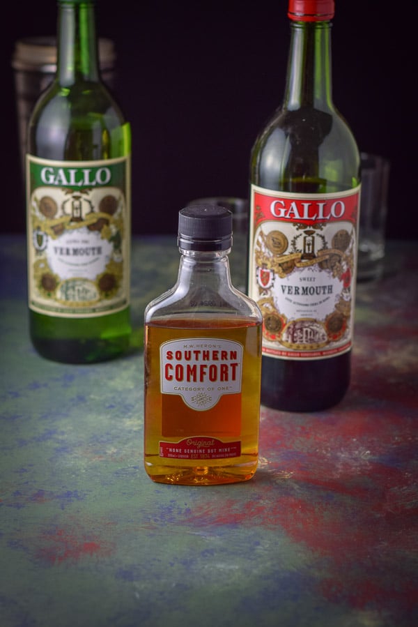 Southern Comfort, sweet vermouth, dry vermouth on a very colorful table