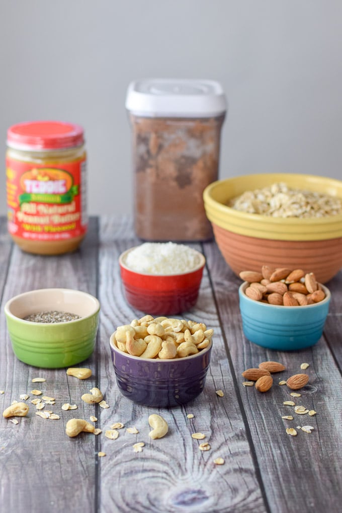 Cashews, almonds, chia seeds, shredded coconut, cocao, peanut butter and oats on a grey table