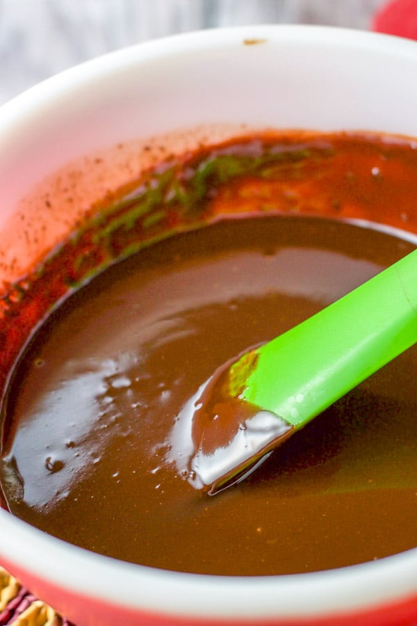 All the ingredients mixed together in a red bowl with a green spatula in it