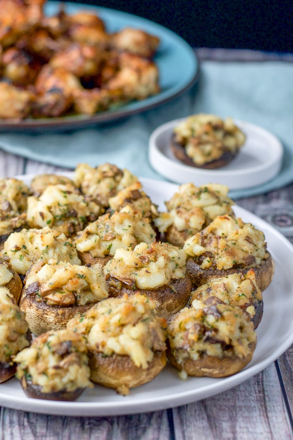 Plate of stuffed mushrooms with some chicken wings in the background