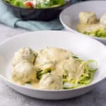 A deep dish of zoodles with a cream sauce and meatballs - square
