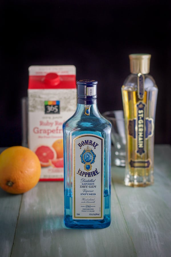 Gin, St. Germain liqueur and grapefruit on a green board