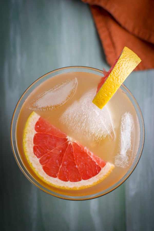 Overhead view of the pinkish Cocktail with a floating slice of grapefruit and another one on the rim of the glass