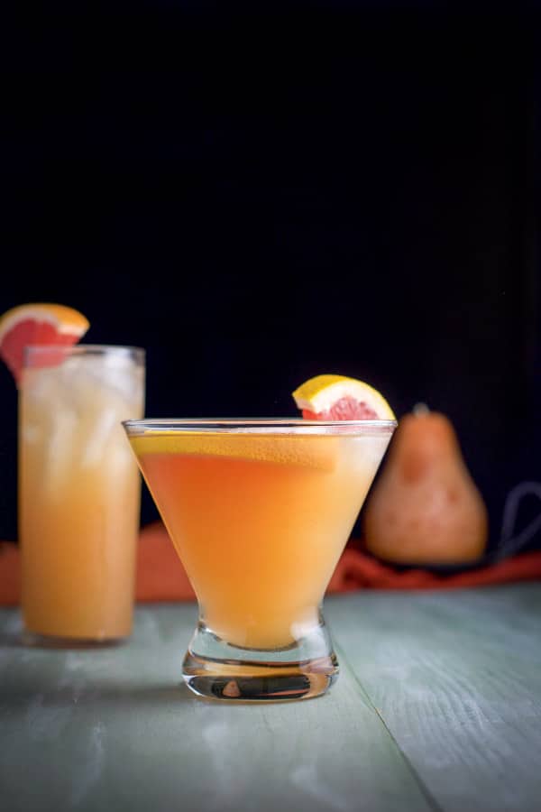 Vertical view of the shorter glass with the grapefruit floating in the liquid