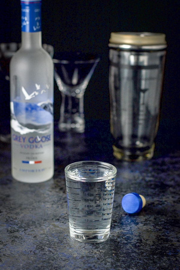 Vodka poured out for the drink with the bottle in the background