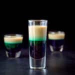 The tall glass filled with the layered shot - square