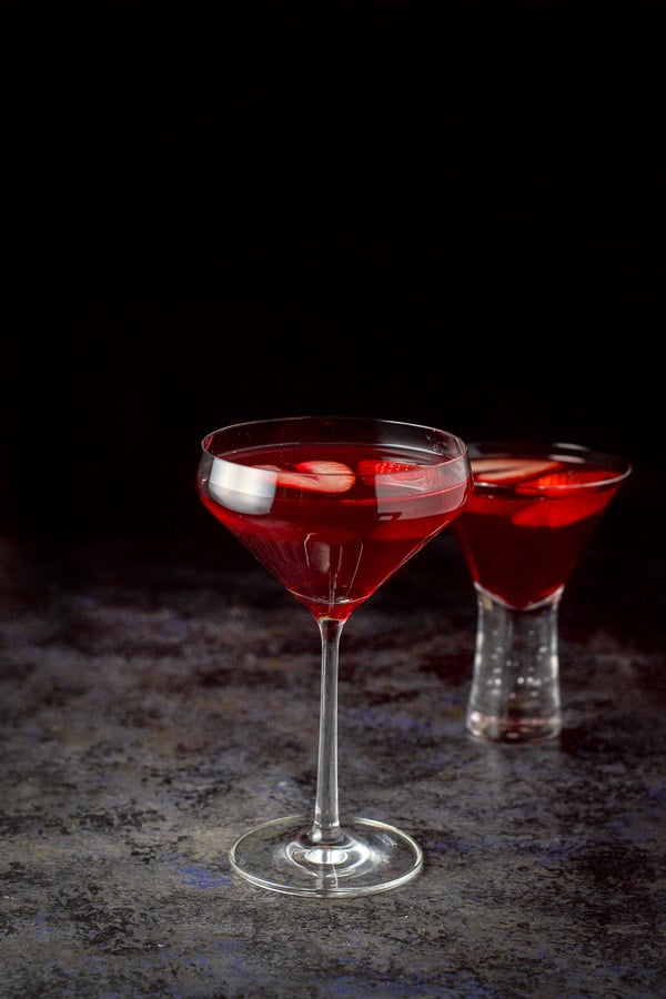 The red martini in a tall glass and a shorter glass behind it