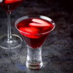 Close up of the bubble glass with the love martini in it with sliced strawberries floating in it