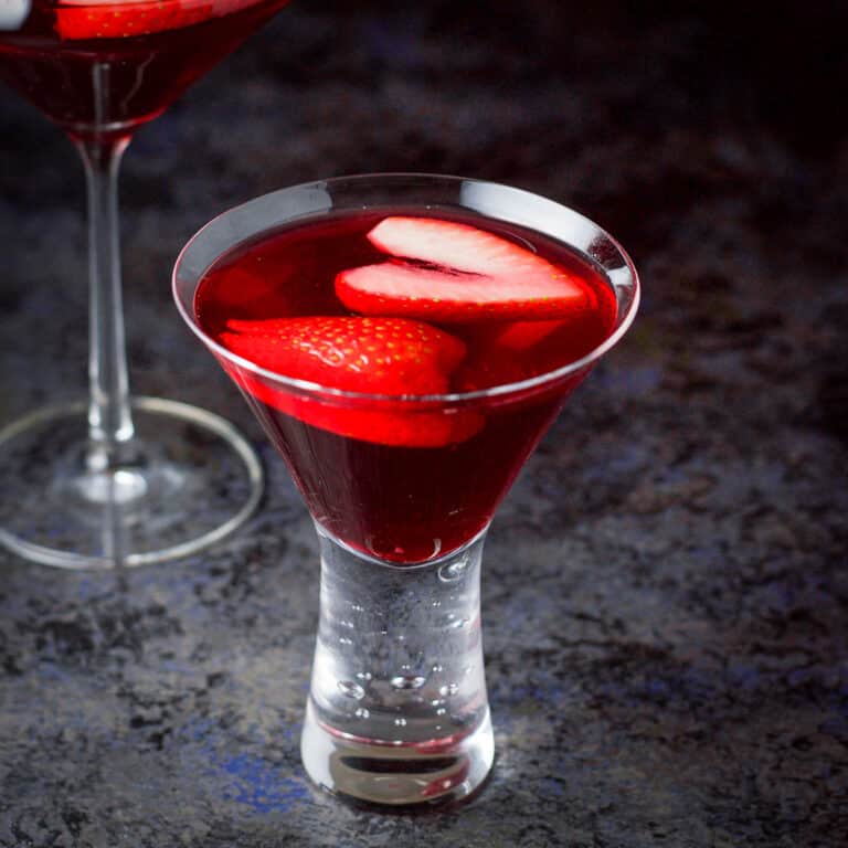 Close up of the bubble glass with the love martini in it with sliced strawberries floating in it