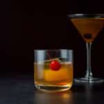 Vertical view of the short glass with a red cherry and the cocktail - square
