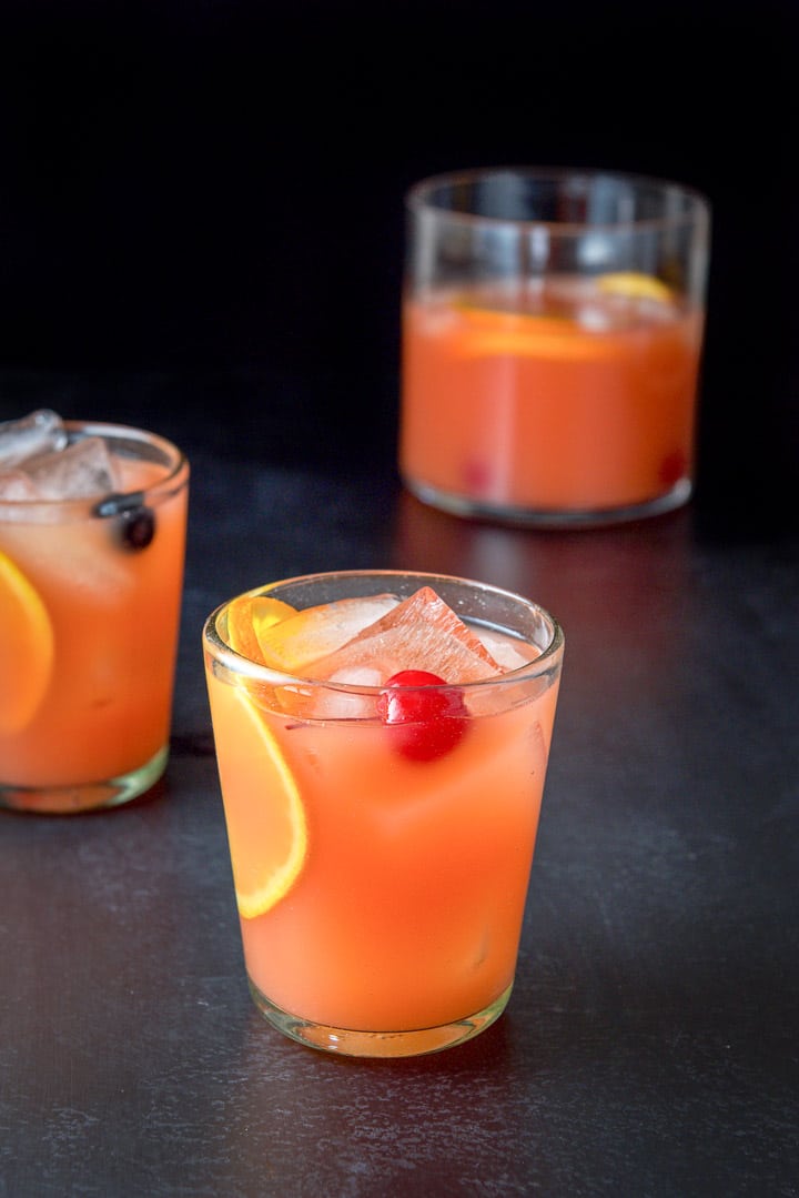 Two glasses filled with the cocktail with the vase in the background