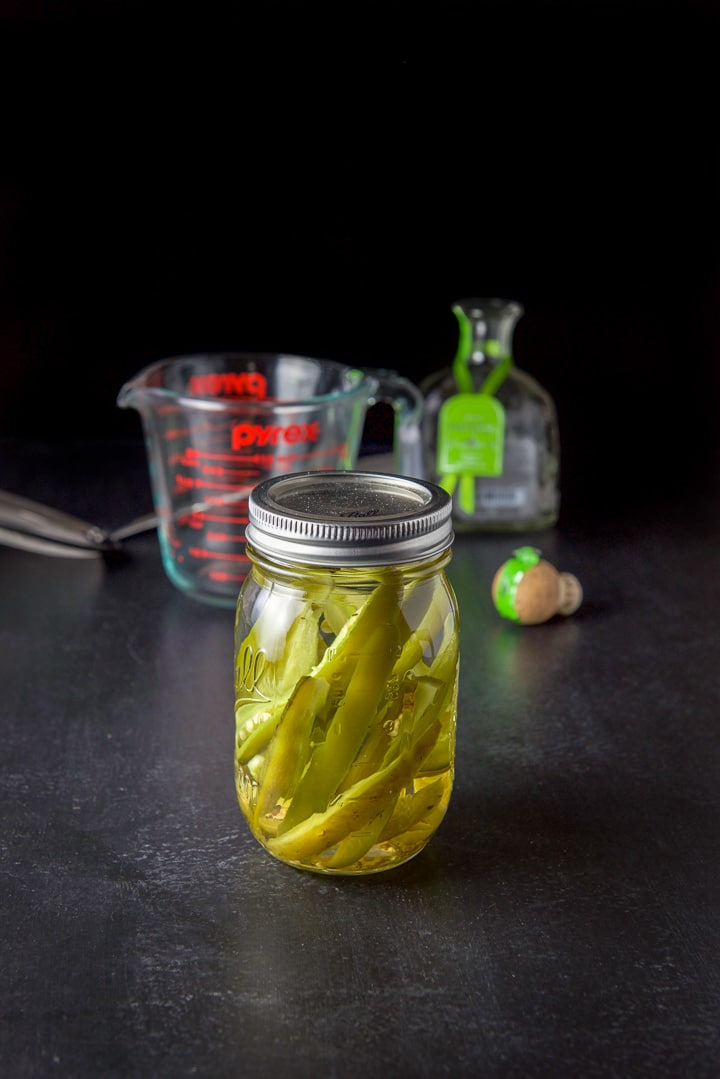 A jar of jalapeño tequila ready after 4 days with the bottle in the background