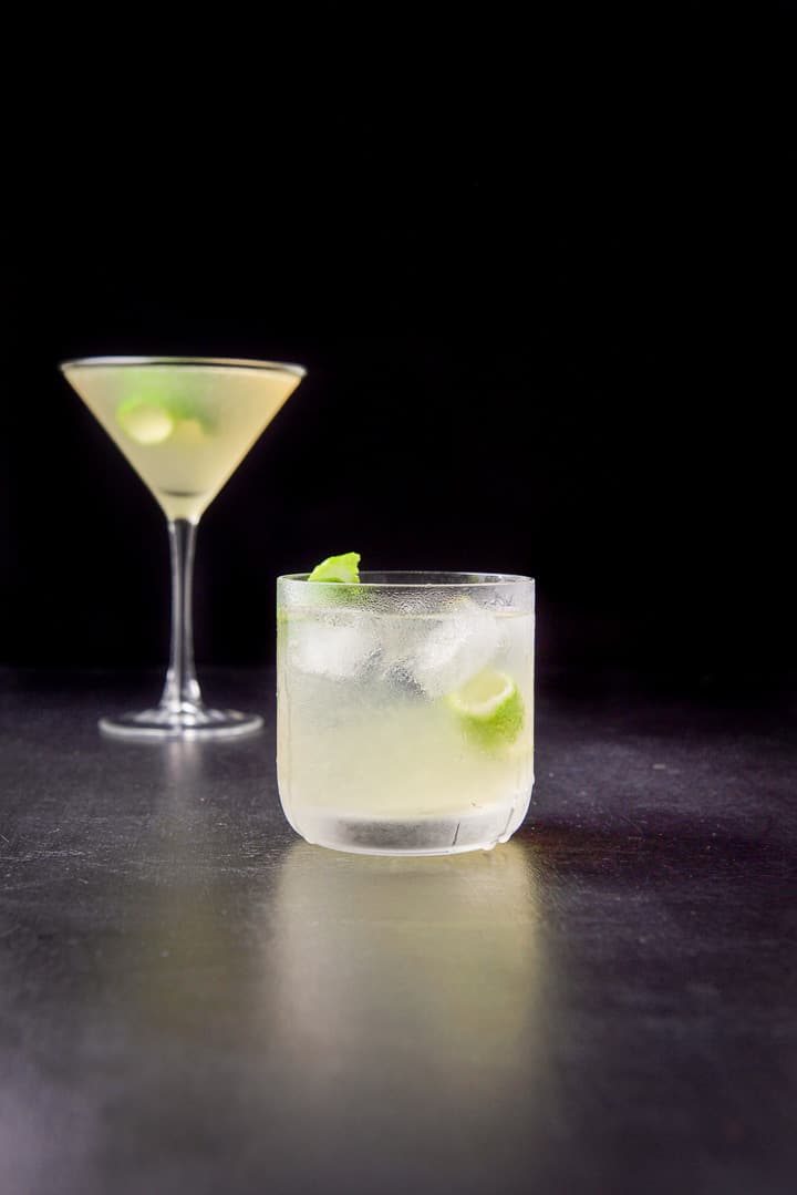 Vertical view of the gimlet in the old fashioned glass in front of the classic martini glass