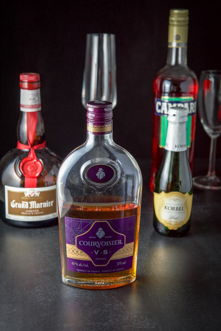Cognac, Grand Marnier, Campari and champagne on a black table