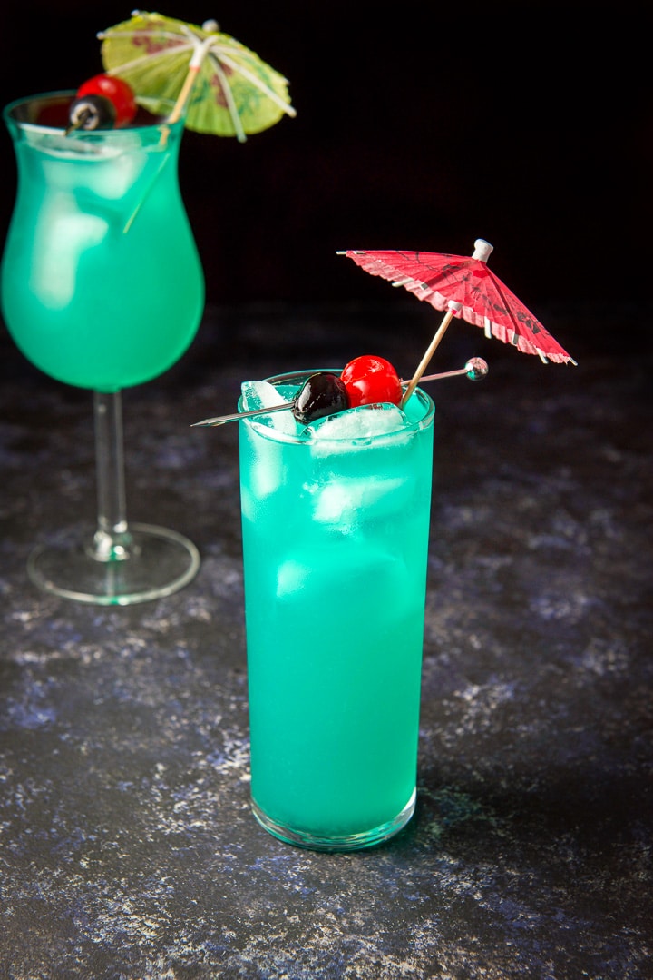 The collins and tulip glasses filled with the cocktail with cherries and umbrellas