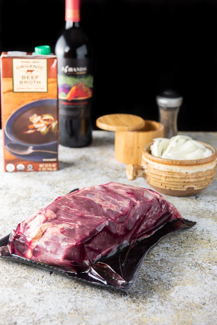 Bottom round roast, beef broth, onion, wine and salt & pepper on the table