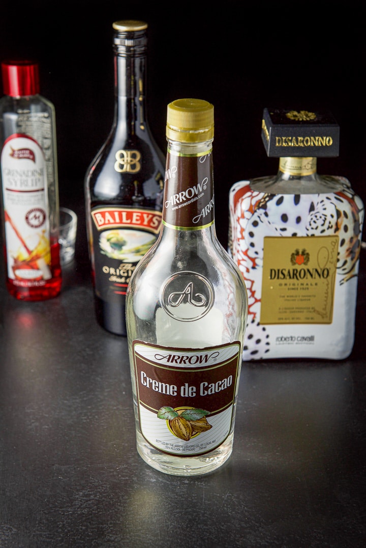 Creme de cacao, amaretto, Baileys Irish cream, grenadine on a table