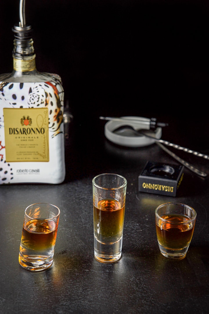 Amaretto layered in the three glasses with the bottle in the background