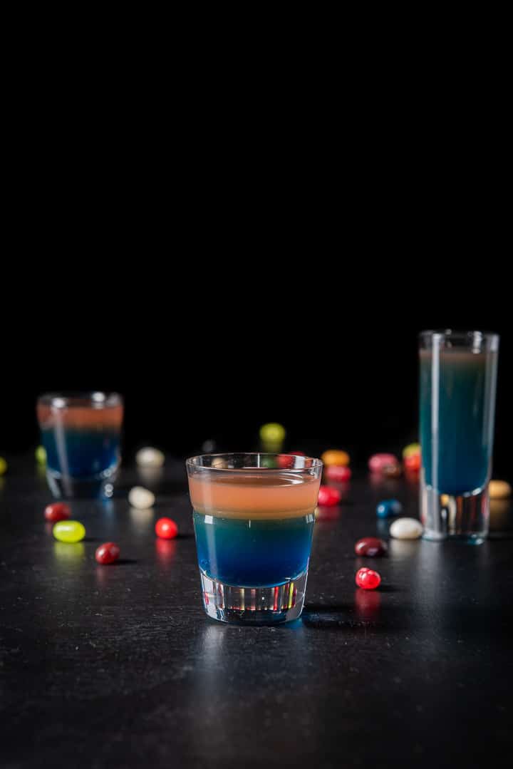 Vertical view of the beveled glass in front of the other two glasses. There are jelly beans strewn on the table