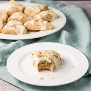 Square photo of the the scone with a bite taken out of it on a plate