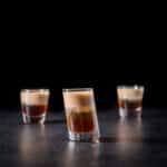 Vertical view of the layered shot in the tilted glass with the two other glasses behind it - square