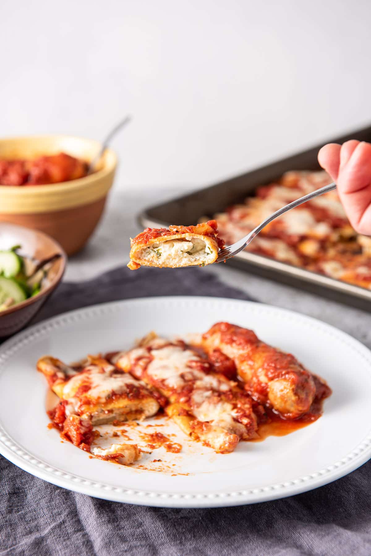 A piece of baked manicotti on a fork ready to be eaten