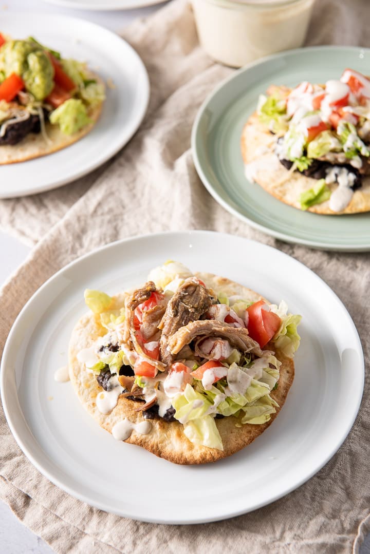 Pulled pork and other ingredients on the tortilla with two other plates